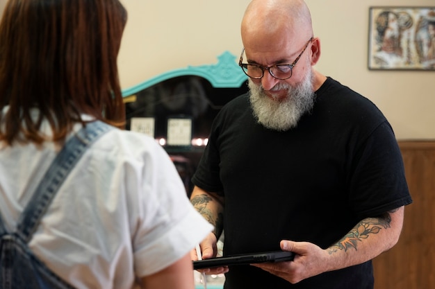 Tatuador experimentado que trabaja en el tatuaje del cliente.