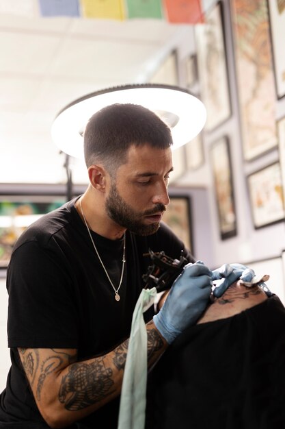 Tatuador de tiro medio en el trabajo