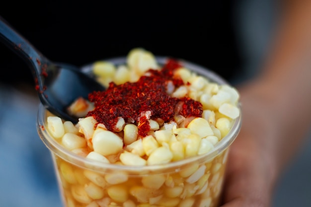 Foto gratuita taza de alto ángulo con deliciosos esquites.