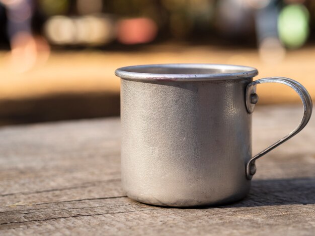 Taza de aluminio sobre superficie de madera.