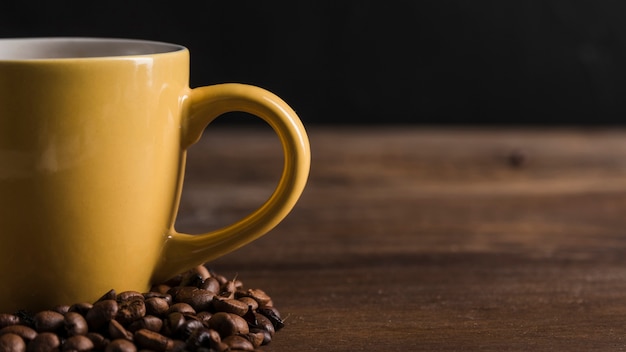 Taza amarilla con granos de café