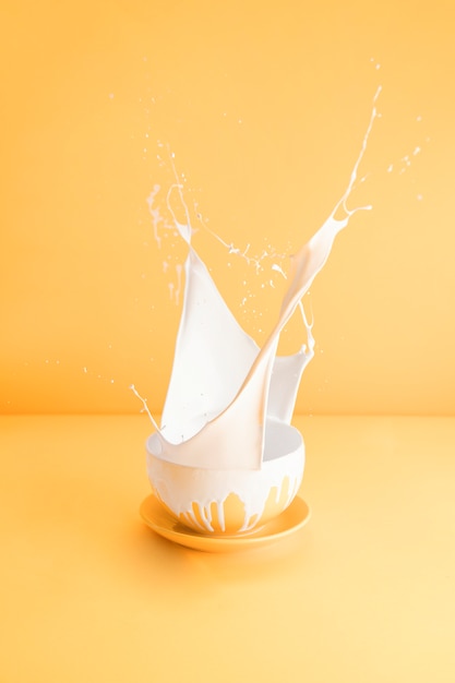 Taza amarilla con leche derramada