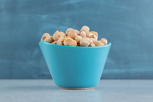 Una taza azul profunda llena de deliciosa comida redonda.