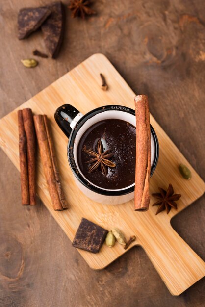 Taza con bebida aromática de chocolate caliente sobre tabla de madera
