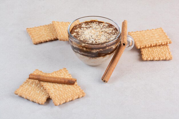 Una taza de bebida deliciosa con galletas y canela en rama