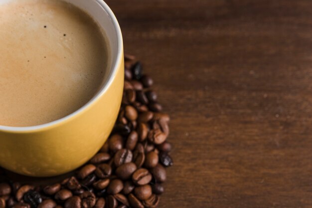 Taza con bebida y granos de café.