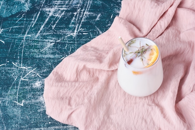 Una taza de bebida con leche y hierbas en azul.