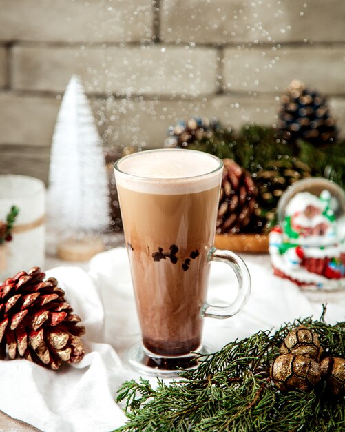 Una taza de café al lado de decoraciones navideñas