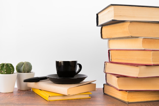 Taza de café al lado de pila de libros