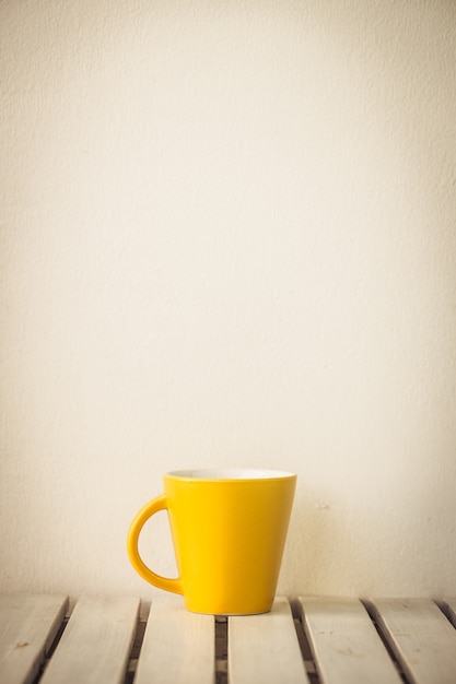 Taza de café amarillo en mesa