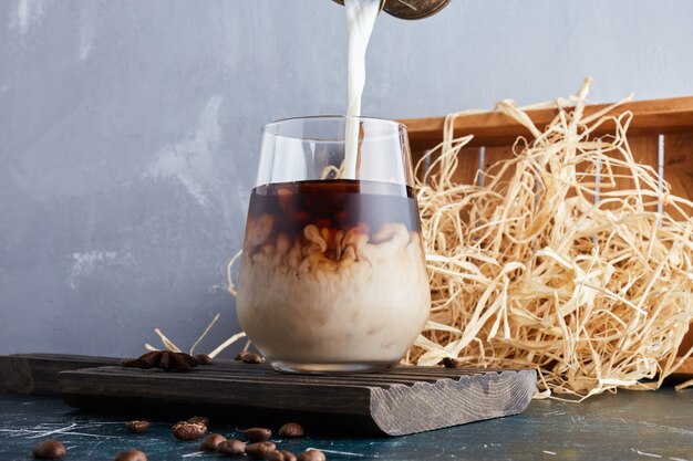 Una taza de café y añadiendo más leche.