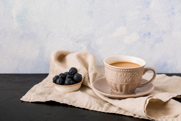 Foto gratuita taza de café y arándanos