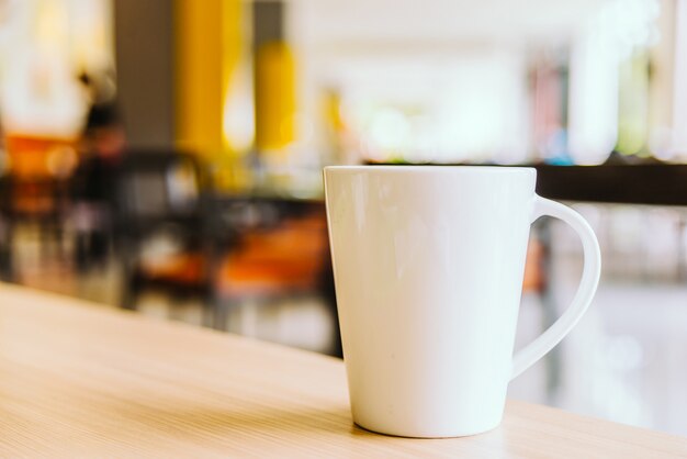 Taza de café blanco en la cafetería