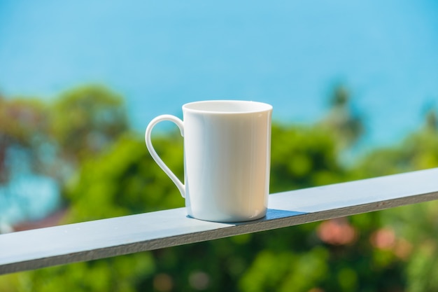 Taza de café blanco con vista al mar.