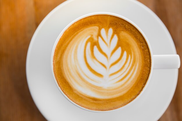 Taza de café con una brizna de trigo dibujado en la espuma