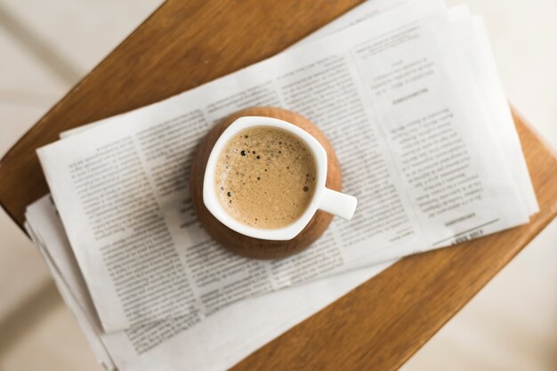 Taza con café caliente en periódicos