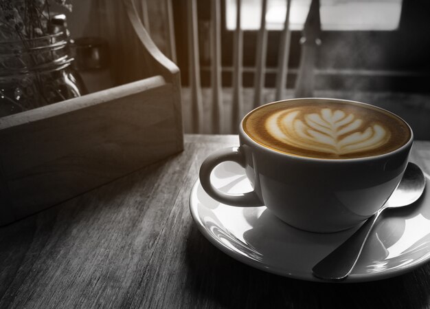 Taza de café caliente con ventana de luz cálida mañana