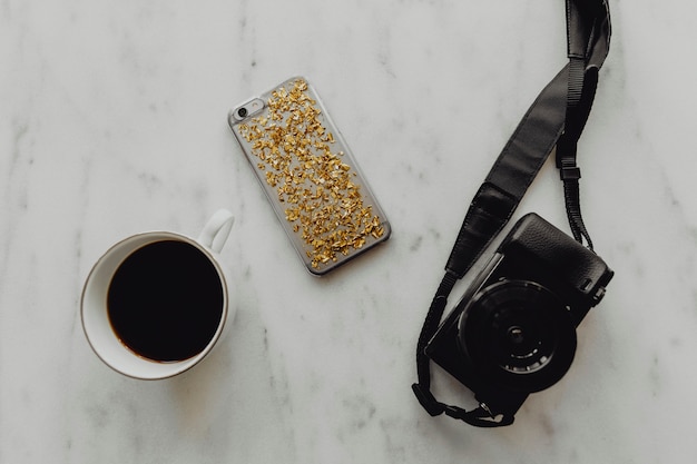 Foto gratuita taza de café con una cámara réflex digital y un teléfono.