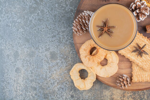 Taza de café con canela y piñas en placa de madera. Foto de alta calidad