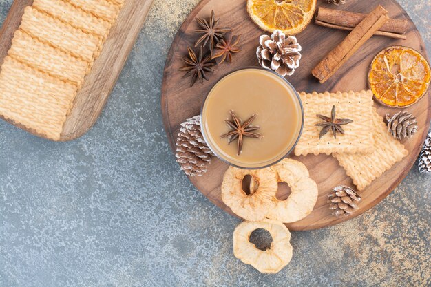 Taza de café con canela y piñas en placa de madera. Foto de alta calidad