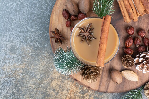 Taza de café con canela y piñas en placa de madera. Foto de alta calidad