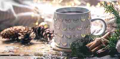 Foto gratuita taza de café en casa en una mesa de madera con bultos en un fondo con decoraciones