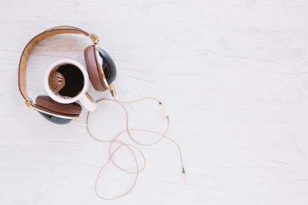 Taza de café cerca de auriculares