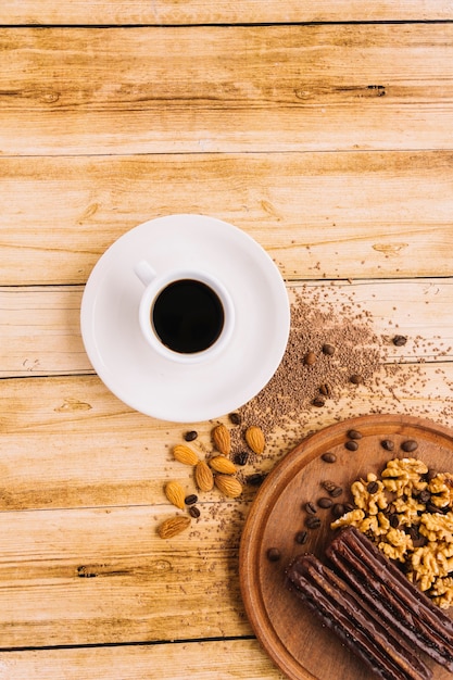 Foto gratuita taza de café cerca de nueces en la tabla de cortar