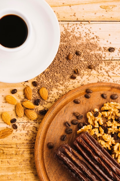 Foto gratuita taza de café cerca de nueces en tajadera