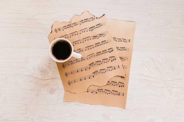 Taza de café cerca de la partitura