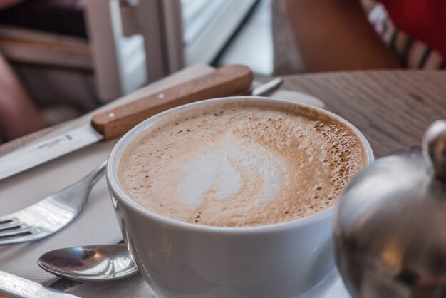 Taza de café cremoso y cubiertos