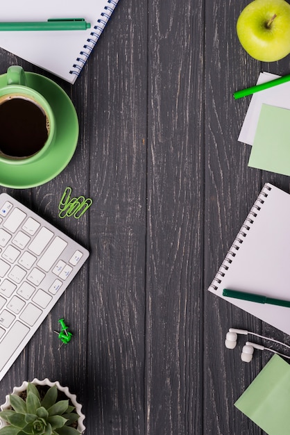 Taza de café con cuaderno y planta suculenta en escritorio de madera