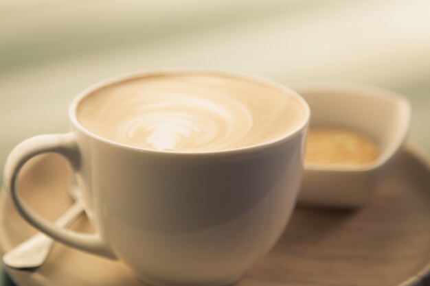 Taza de café con un cuenco con galletas