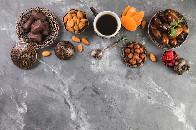 Taza de café con dátiles frutas y frutos secos.