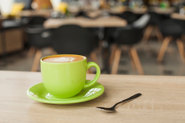 Taza de café deliciosa con arte del latte en la tabla en el restaurante