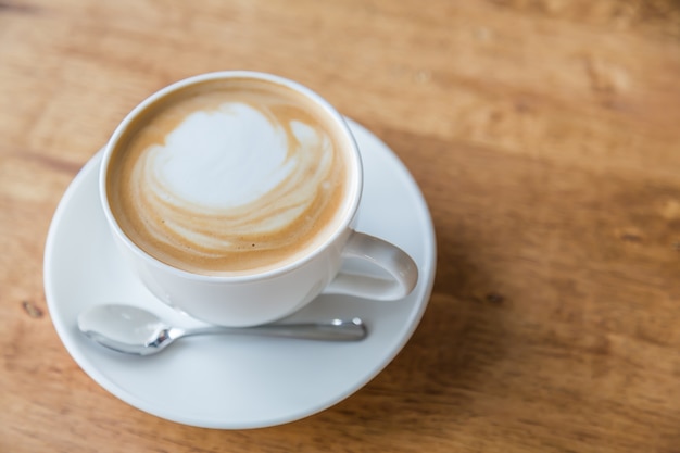 Taza de café deliciosa sobre mesa de madera