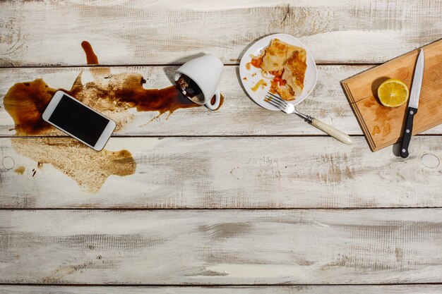 Taza de café derramado sobre la mesa de madera