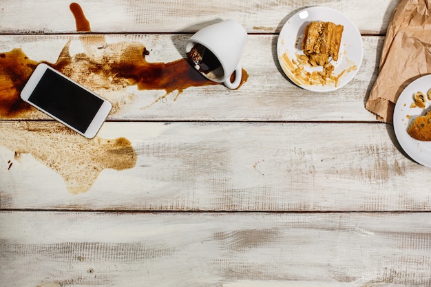 Taza de café derramado sobre la mesa de madera