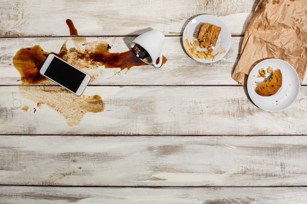 Foto gratuita taza de café derramado sobre la mesa de madera