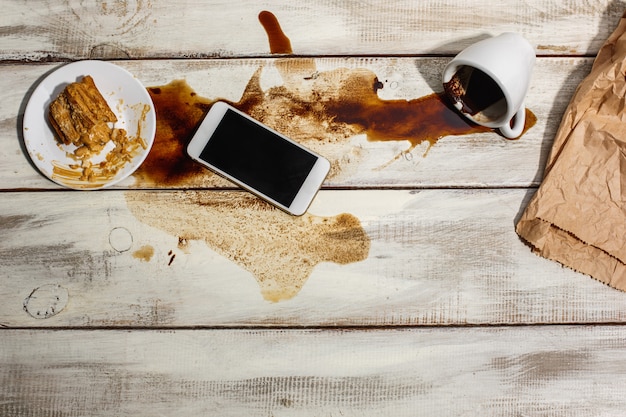 Foto gratuita taza de café derramado sobre la mesa de madera