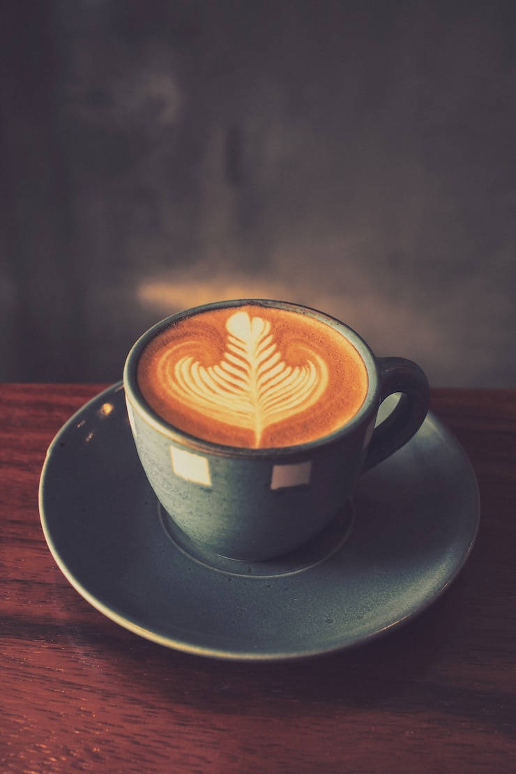 Foto gratuito taza de café con un dibujo en la espuma