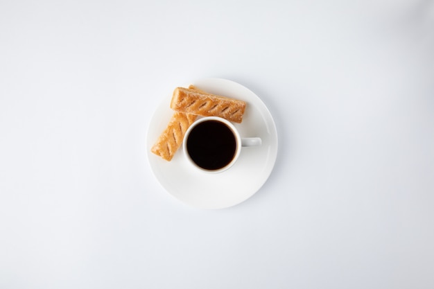 Taza de café con dulces aislados en blanco