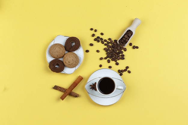 Taza de café con especias, galletas, hierbas secas y granos de café.