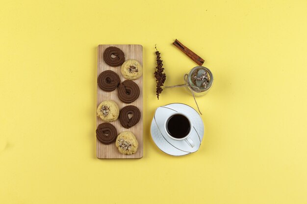 Taza de café con especias, galletas, hierbas secas y granos de café.