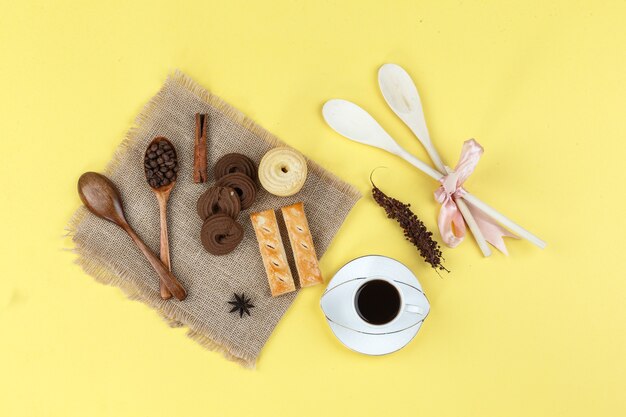 Taza de café con especias, galletas, hierbas secas y granos de café.