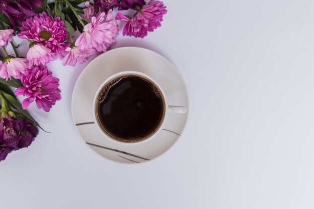 Taza de café y flores de color púrpura