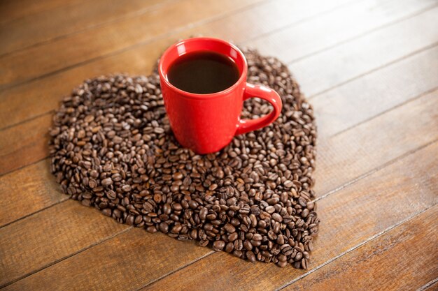Taza de café con forma de corazón los granos de café