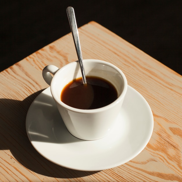 Taza de café fresco en el escritorio en la cafetería