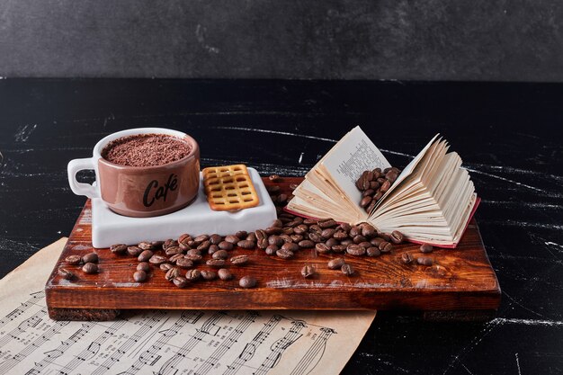 Taza de café con frijoles alrededor.