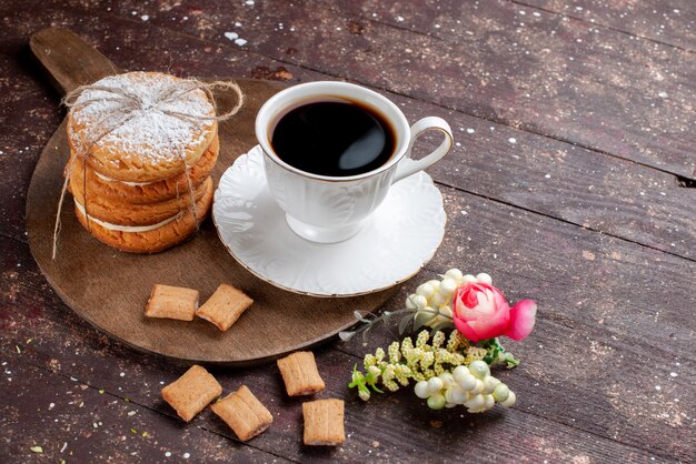 Taza de café fuerte y caliente junto con galletas y bizcochos en un escritorio de madera marrón, pastel de frutas, bizcocho de café dulce